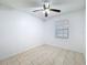 Bright bedroom features tile flooring, a ceiling fan, and a window letting in natural light at 1328 S Oxalis Ave, Orlando, FL 32807
