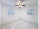 Well-lit bedroom with tile flooring, ceiling fan, and two windows for natural light at 1328 S Oxalis Ave, Orlando, FL 32807
