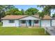 Attractive single-story home boasts a manicured lawn, and inviting front porch with eye-catching blue pillars at 1328 S Oxalis Ave, Orlando, FL 32807