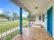 Inviting covered porch detailed with decorative railings and blue pillars, enhancing curb appeal and outdoor living at 1328 S Oxalis Ave, Orlando, FL 32807