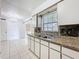 Well-lit kitchen featuring granite countertops and ample cabinet space, with easy access to the dining area at 1328 S Oxalis Ave, Orlando, FL 32807