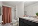 Bathroom featuring a vanity with cabinets, a sink, a mirror, and a tub-shower with a dark peach curtain at 141 Claire Ln, Davenport, FL 33837