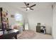 A well-lit bedroom featuring a unique rug, comfortable chair, and a ceiling fan at 141 Claire Ln, Davenport, FL 33837