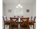 Classic dining area featuring a dark wood table with seating for six, with bright natural light from the window at 141 Claire Ln, Davenport, FL 33837