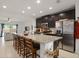 Well-appointed kitchen with a granite island, stainless steel appliances, dark wood cabinets, and an open view to the living area at 141 Claire Ln, Davenport, FL 33837