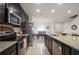 Stylish kitchen featuring dark wood cabinetry, stainless steel appliances, granite countertops, and an open layout for easy socializing at 141 Claire Ln, Davenport, FL 33837