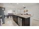 Bright, open kitchen with a large island, stainless steel appliances, dark cabinetry, and seamless flow to the dining area at 141 Claire Ln, Davenport, FL 33837