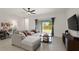 Comfortable living room featuring tile floors, a ceiling fan, and sliding glass doors to the yard at 141 Claire Ln, Davenport, FL 33837