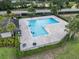 Aerial view of the community pool, featuring a fenced-in area and palm trees, ideal for relaxation and recreation at 141 Claire Ln, Davenport, FL 33837