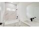 Beautiful bathroom features a tub with marble tile surround, white vanity, and modern black fixtures at 15621 Sw 37Th Cir, Ocala, FL 34473