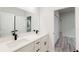 Bathroom featuring double sinks with quartz countertops, modern black fixtures, and grey wood floors at 15621 Sw 37Th Cir, Ocala, FL 34473