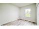 Bright bedroom with light-colored wood floors, a window letting in natural light, and a large white closet at 15621 Sw 37Th Cir, Ocala, FL 34473