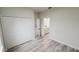 Bedroom featuring wood floors and a closet with doors, leading to a bathroom with quartz countertops at 15621 Sw 37Th Cir, Ocala, FL 34473