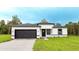 Modern home with a dark garage door, black framed windows, and a well-manicured lawn at 15621 Sw 37Th Cir, Ocala, FL 34473