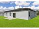 A home exterior with a backyard including a concrete patio and a large grassy area at 16057 Sw 17Th Ave, Ocala, FL 34473