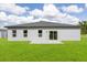 A home exterior with a backyard including a concrete patio and a large grassy area at 16057 Sw 17Th Ave, Ocala, FL 34473
