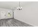 Open dining area with modern chandelier and light gray flooring, adjacent to front door at 16057 Sw 17Th Ave, Ocala, FL 34473
