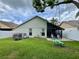 A spacious backyard featuring a grassy lawn, mature tree with a swing, and a screened patio for outdoor enjoyment at 1659 Canton Ln, Oviedo, FL 32765