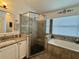 This bathroom features a shower and soaking tub with tile surround and a vanity with granite countertop at 1659 Canton Ln, Oviedo, FL 32765