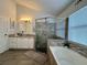 This bathroom features a shower and soaking tub with tile surround and a vanity with granite countertop at 1659 Canton Ln, Oviedo, FL 32765