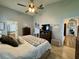 Bright bedroom with a ceiling fan, walk-in closet, and an attached bathroom with modern fixtures at 1659 Canton Ln, Oviedo, FL 32765