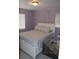 Inviting bedroom featuring soothing lavender walls, plush bedding, ample natural light, and bright, white trim at 233 N Hudson St, Orlando, FL 32835