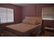 Serene bedroom featuring soothing lavender walls, plush bedding, ample natural light, and bright, white trim at 233 N Hudson St, Orlando, FL 32835