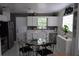Bright kitchen with white cabinets, a window view, stainless steel appliances, and a cozy dining area at 233 N Hudson St, Orlando, FL 32835