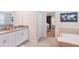 Modern bathroom with double sink vanity, bathtub, and doorway to bedroom at 2850 Bookmark Dr, Kissimmee, FL 34746