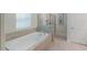 Elegant bathroom with a soaking tub, tiled walls, and a separate glass-enclosed shower at 2850 Bookmark Dr, Kissimmee, FL 34746