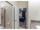 An open doorway reveals a view from the bathroom into a cozy bedroom with blue bedding and gray carpeting at 2850 Bookmark Dr, Kissimmee, FL 34746