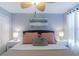 Well-lit bedroom featuring a fan, elegant lamps, a soft color palette, and cozy bedding for a relaxing retreat at 2850 Bookmark Dr, Kissimmee, FL 34746