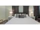 Bright bedroom featuring a king-size bed, bedside tables with lamps, and modern decor at 2850 Bookmark Dr, Kissimmee, FL 34746