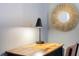 Modern desk with stylish lamp and minimalist mirror create a functional and aesthetically pleasing workspace or vanity area at 2850 Bookmark Dr, Kissimmee, FL 34746