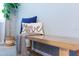 Entryway bench with stylish pillows and throw blanket, complemented by a houseplant, creates a welcoming and cozy atmosphere at 2850 Bookmark Dr, Kissimmee, FL 34746