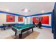 Bright game room featuring a pool table, air hockey, and superhero-themed wall art, creating a fun and engaging space at 2850 Bookmark Dr, Kissimmee, FL 34746