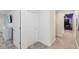 Neutral-colored hallway provides access to other areas of the home, and features two doors and plush carpeting at 2850 Bookmark Dr, Kissimmee, FL 34746