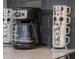 Modern kitchen counter featuring a coffee maker and decorative Disney-themed stacked mugs at 2850 Bookmark Dr, Kissimmee, FL 34746