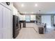 Modern kitchen featuring white cabinetry, stainless steel appliances, a breakfast bar, and a seamless transition to the dining area at 2850 Bookmark Dr, Kissimmee, FL 34746