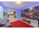 Open living area with a view of the kitchen and a brightly decorated game room in the background at 2850 Bookmark Dr, Kissimmee, FL 34746