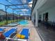 A beautiful screened-in pool with a spa and lounge chairs, perfect for relaxation and entertainment at 2850 Bookmark Dr, Kissimmee, FL 34746