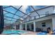 Backyard oasis with screened-in pool, hot tub, basketball hoop, patio seating and outdoor dining at 2850 Bookmark Dr, Kissimmee, FL 34746