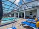 Gorgeous screened-in pool area with a spa, lounge chairs, and outdoor dining, ideal for leisure and entertaining at 2850 Bookmark Dr, Kissimmee, FL 34746
