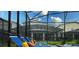 Close up view of the spa and lounge chairs within the screened-in pool area at 2850 Bookmark Dr, Kissimmee, FL 34746