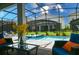 Inviting screened-in pool area with comfortable seating, dining, and lush landscaping at 2850 Bookmark Dr, Kissimmee, FL 34746