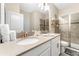 Bathroom featuring a double sink vanity, glass shower, and neutral decor and flooring at 2907 Fable St, Kissimmee, FL 34746