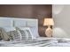 Close-up of a stylish bedroom featuring a queen-sized bed, decorative pillows, and a bedside lamp at 2907 Fable St, Kissimmee, FL 34746