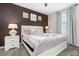 Relax in this bedroom featuring dark accent wall, a luxurious bed and soft natural lighting at 2907 Fable St, Kissimmee, FL 34746