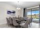 Elegant dining room with a large table, modern chandelier, and view of the outdoor pool at 2907 Fable St, Kissimmee, FL 34746