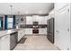 A modern kitchen with stainless steel appliances, stone countertops, and sleek white cabinetry at 2907 Fable St, Kissimmee, FL 34746